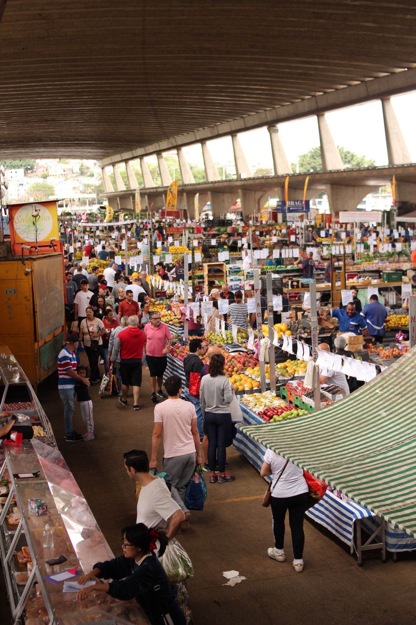 Pasillo interior de un mercado mayorista con puestos de fruta y hortaliza